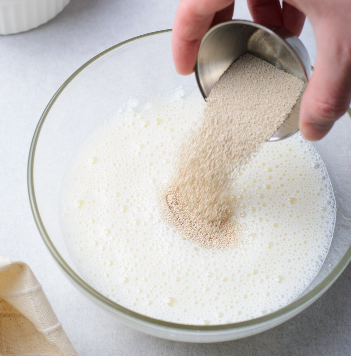 pouring instant yeast into milk