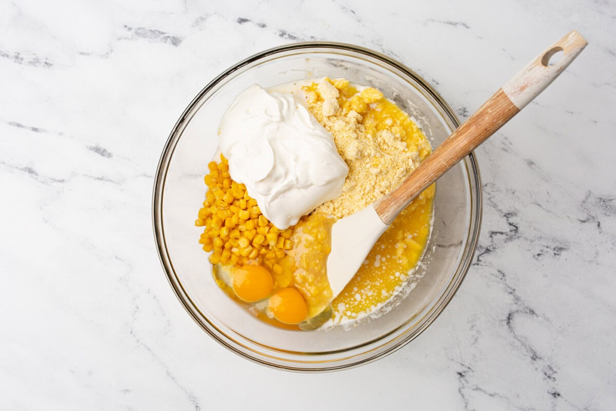 mixing corn casserole ingredients in a bowl