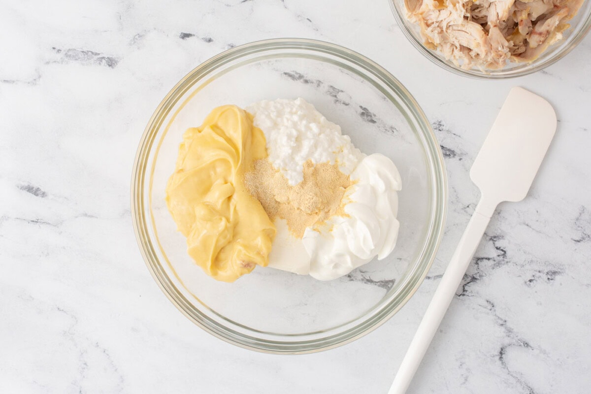 cream cheese, cottage cheese, sour cream, and cream of chicken soup in a mixing bowl
