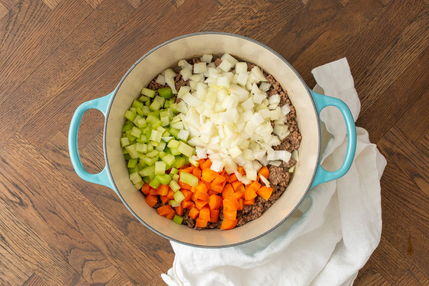 carrots, celery, and onion in a soup pot with ground beef
