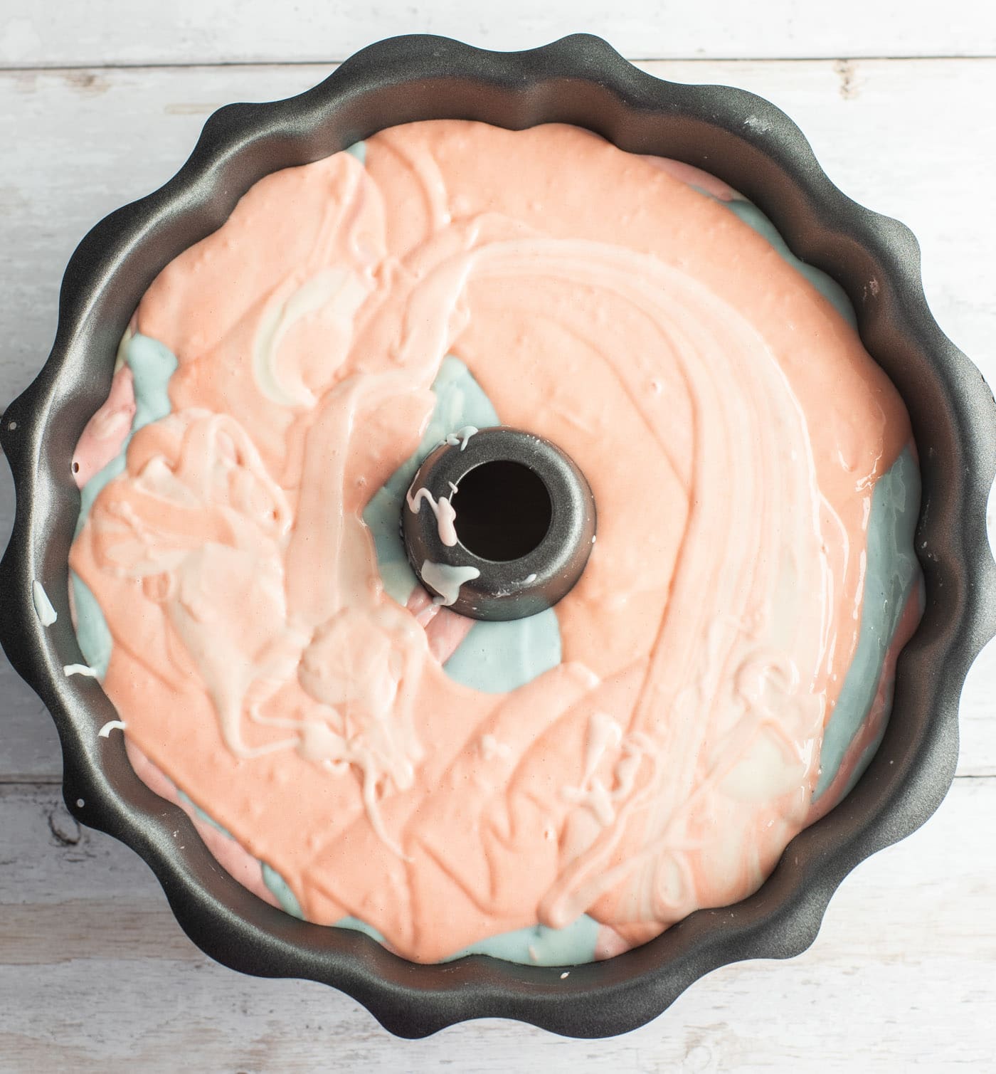 pastel colored cake batter in a bundt pan