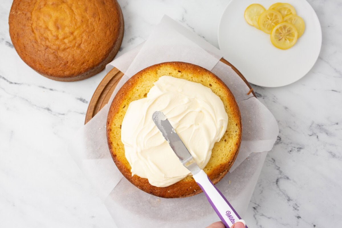icing spatula spreading frosting onto cake