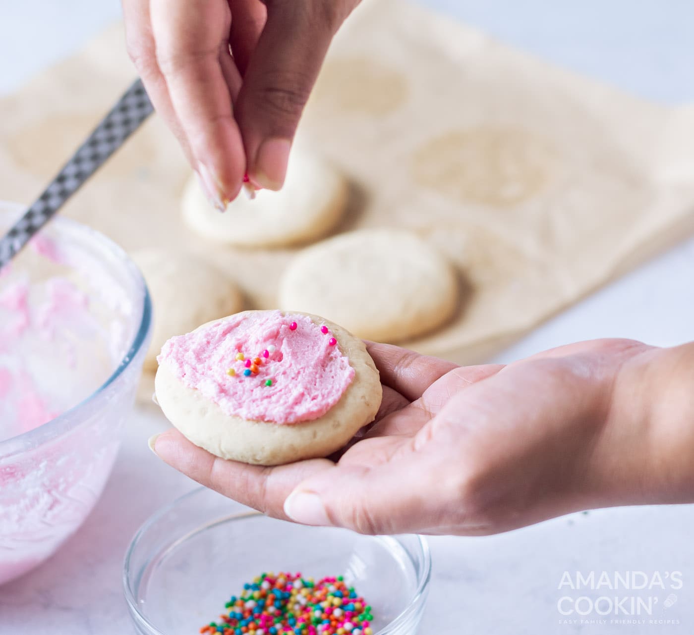 hand adding sprinkles to lofthouse cookies