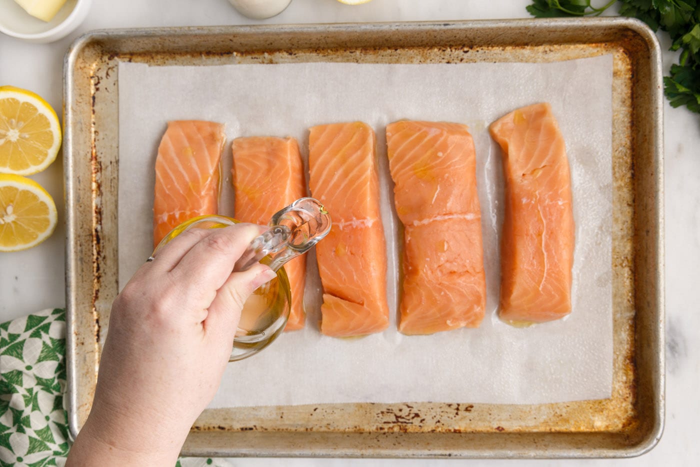 drizzling oil over salmon filets