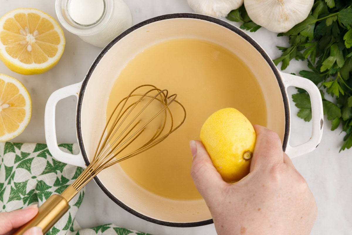 squeezing lemon juice into cream sauce