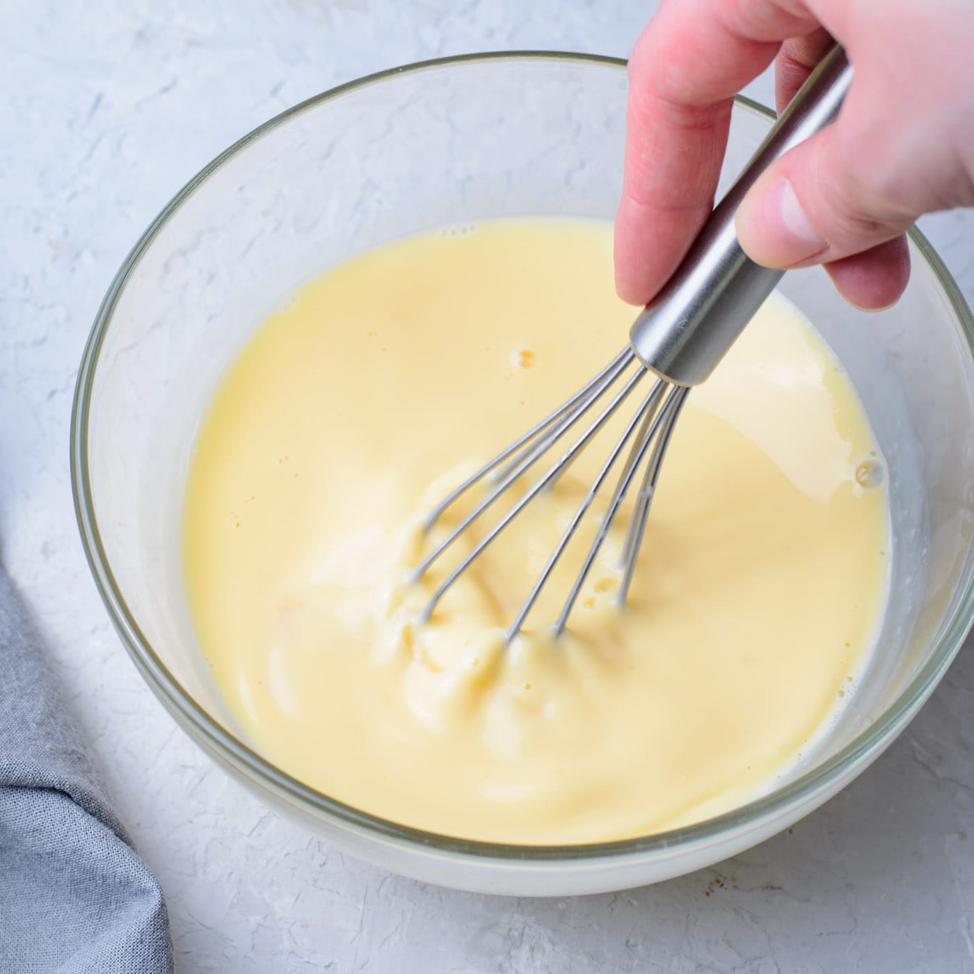eggs, vanilla, milk, and butter whisked in a bowl 