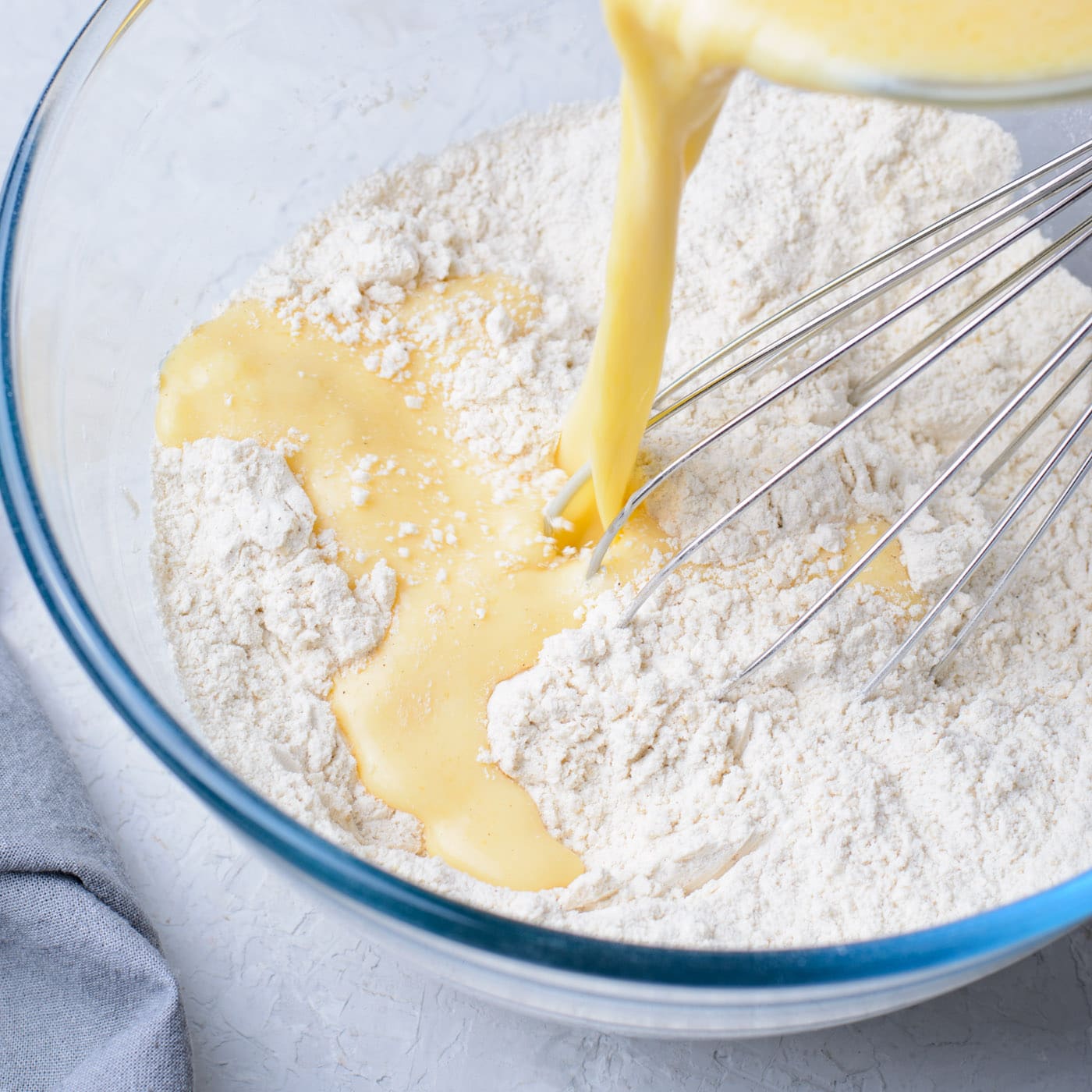 pouring batter into dry ingredients for banana fritters