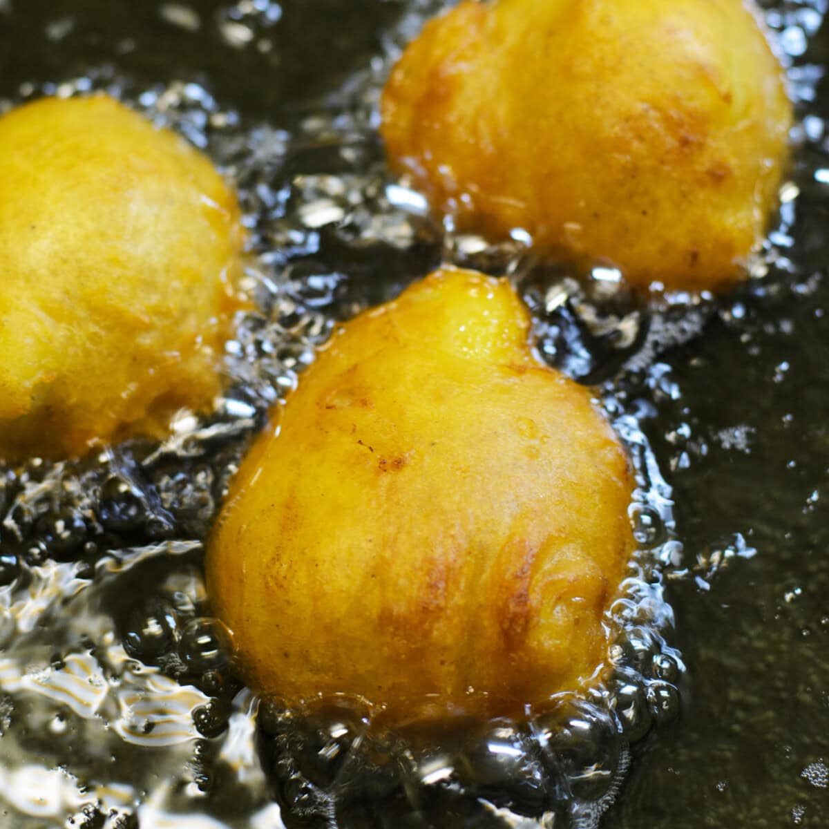 frying banana fritters in a pan