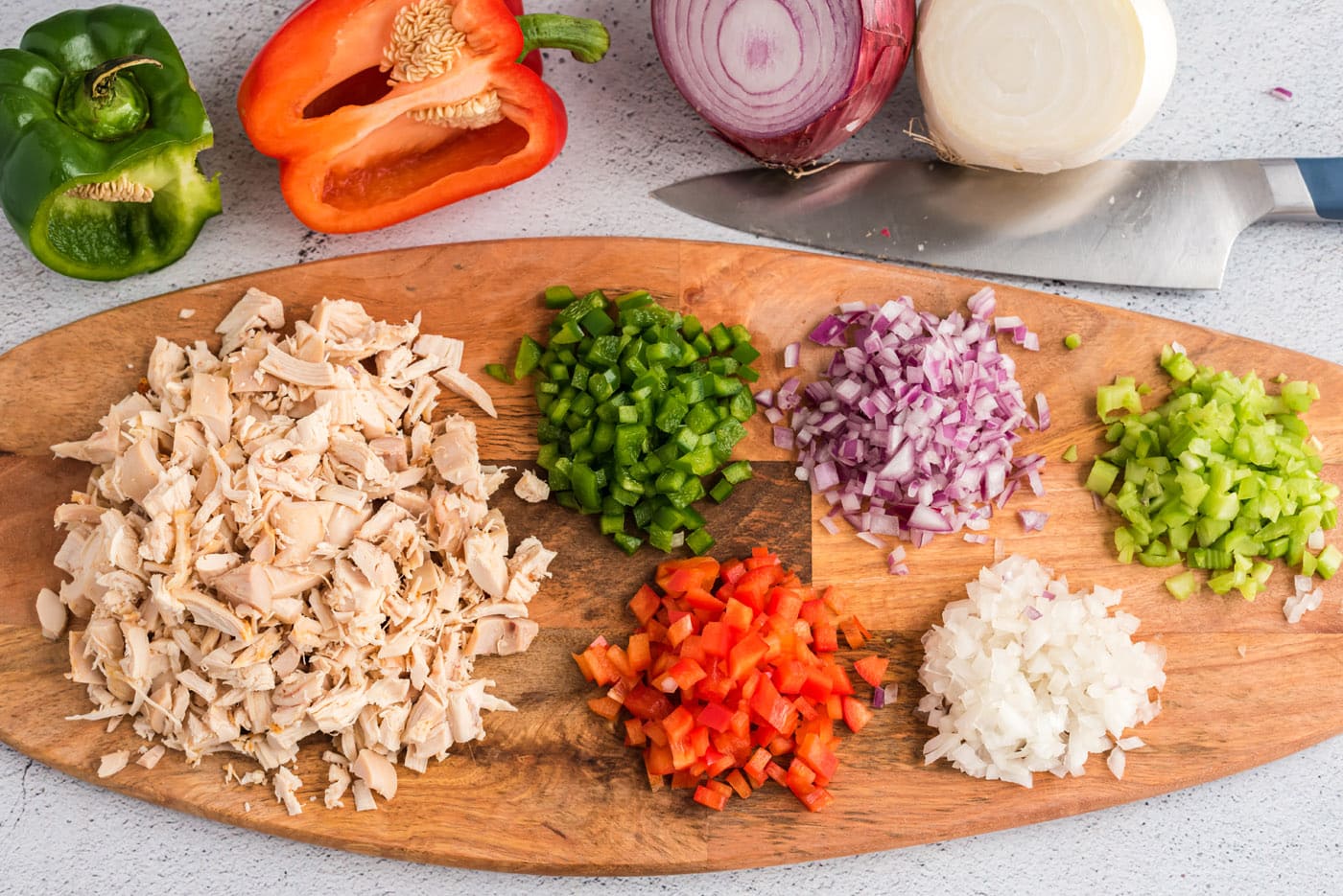 chopped veggies and chicken on a cutting board
