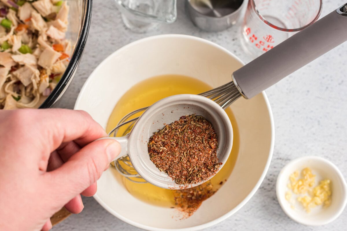 olive oil, garlic, vinegar, broth, and Cajun seasoning in a bowl