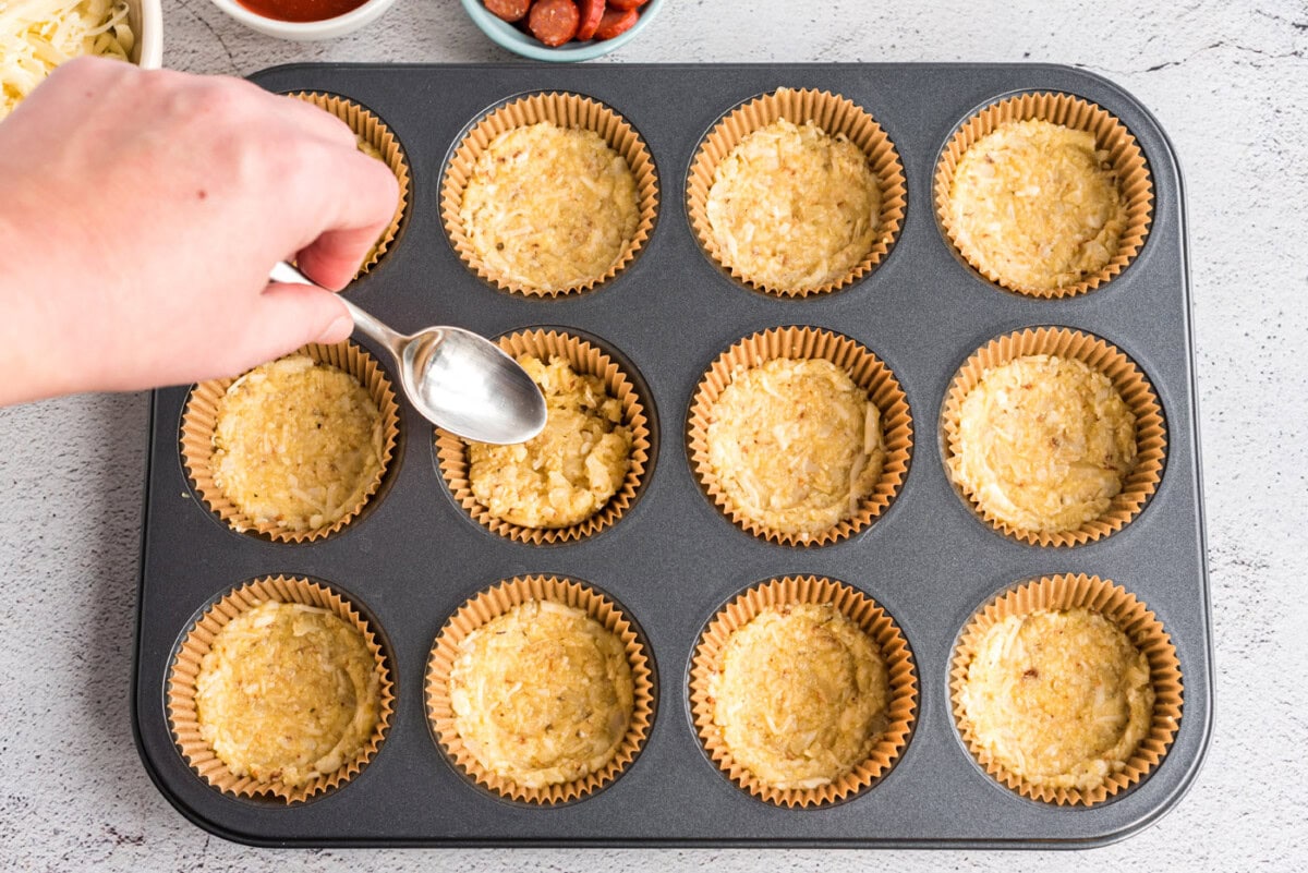 flattening cauliflower crust in muffin tin