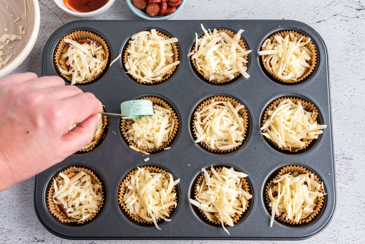 adding cheese to cauliflower pizza bites