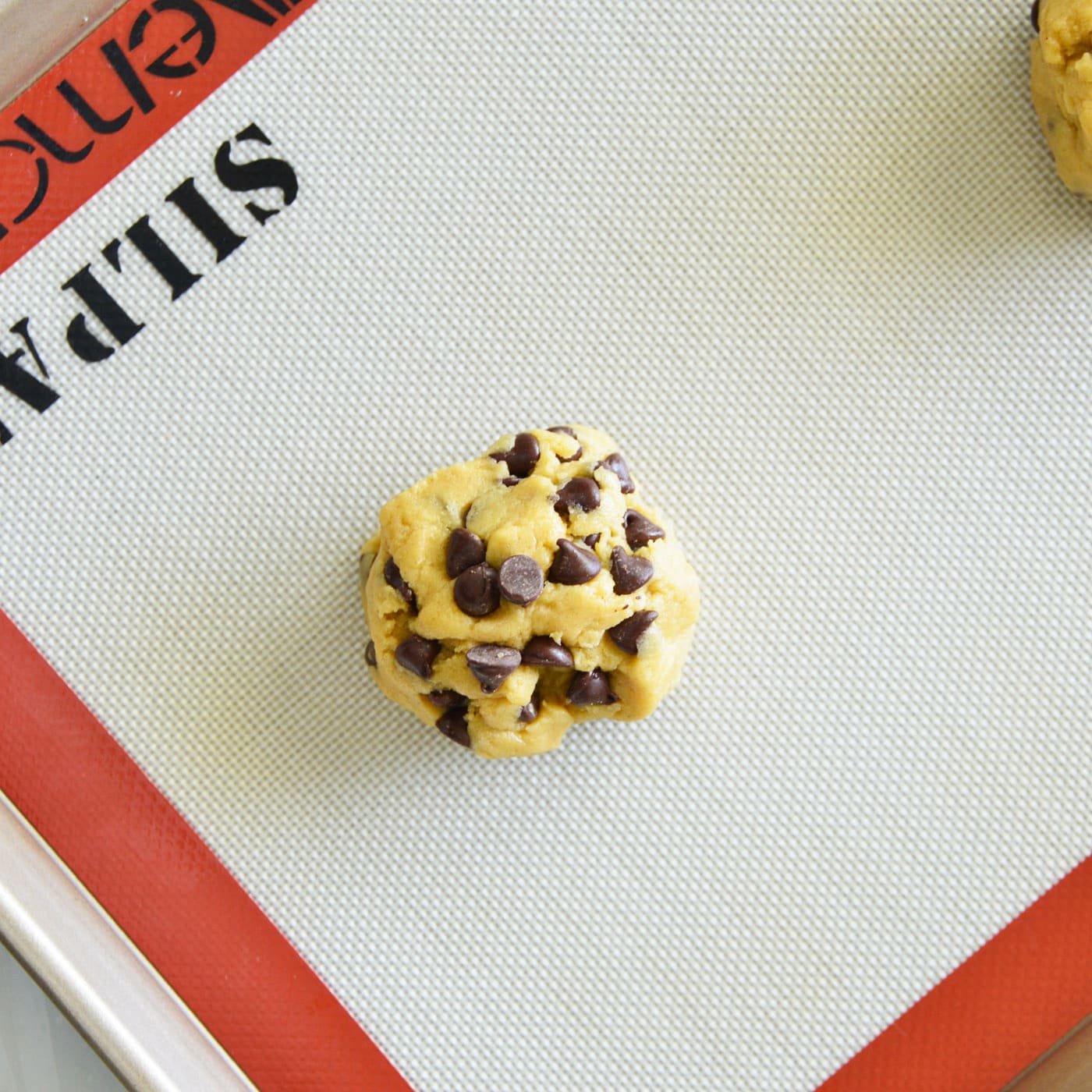 chocolate chip cookie dough ball on baking sheet