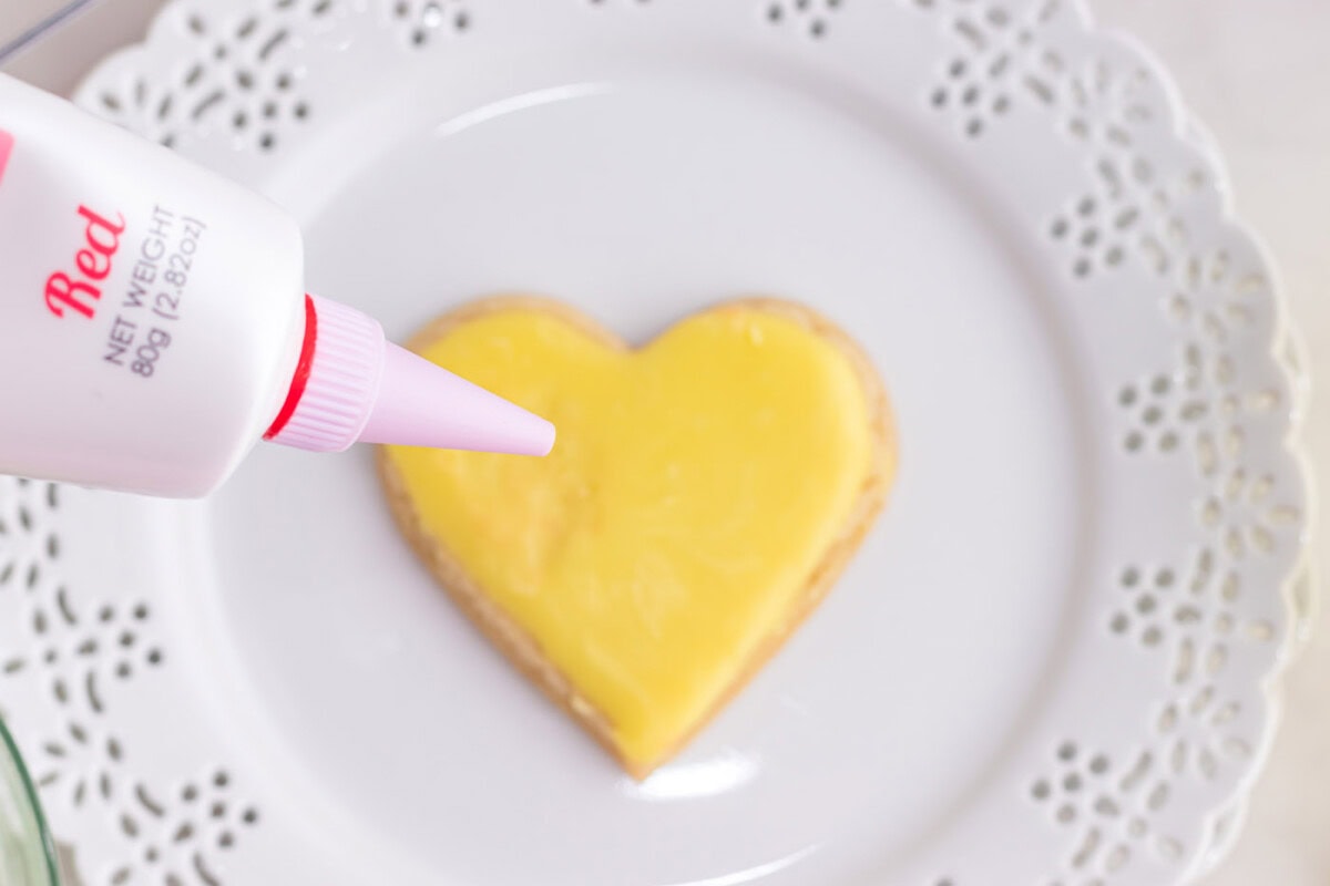 red gel frosting on heart shaped cookie