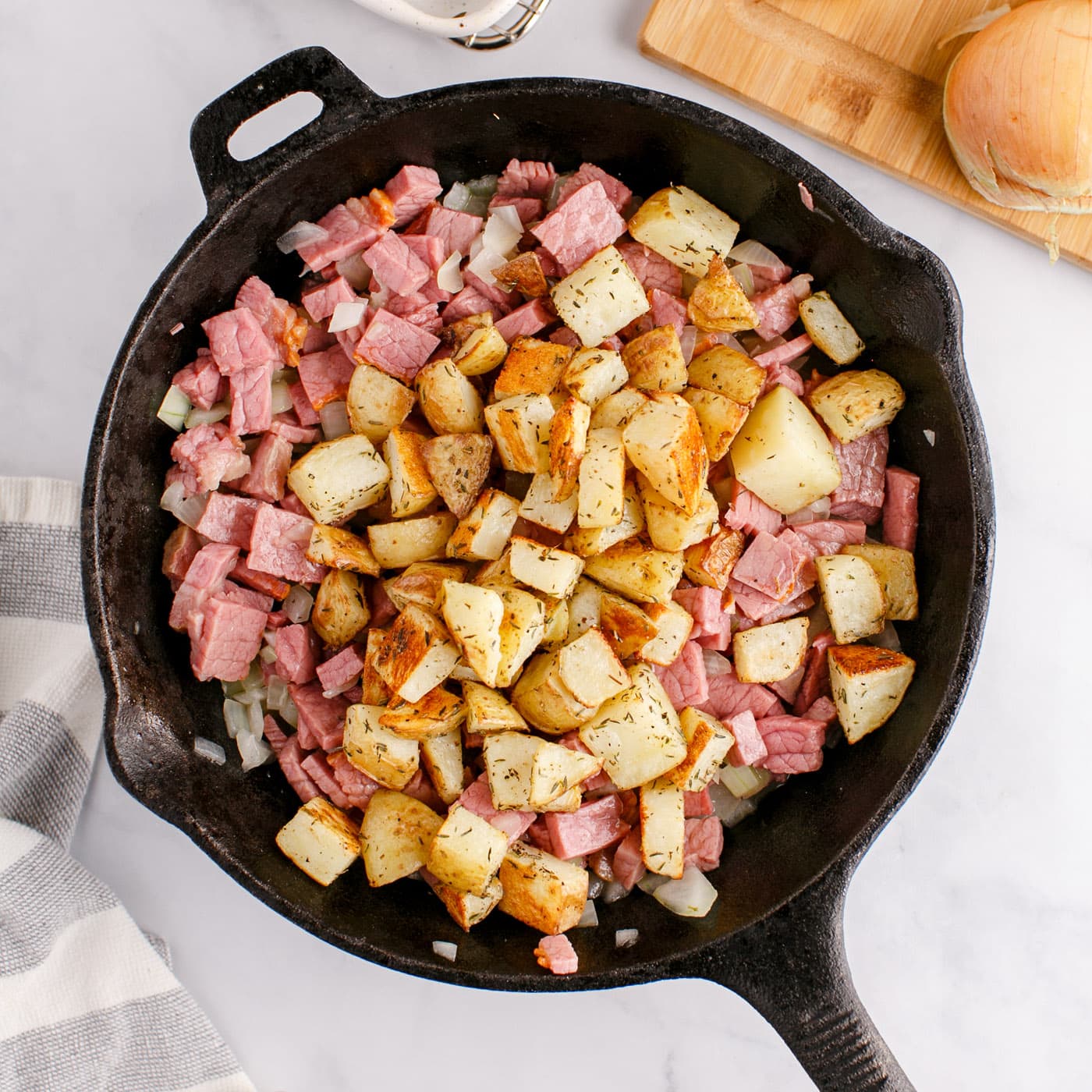 cubed potatoes, corned beef, and onions in a skillet