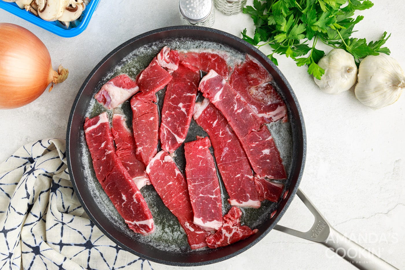 searing steak in a skillet with butter