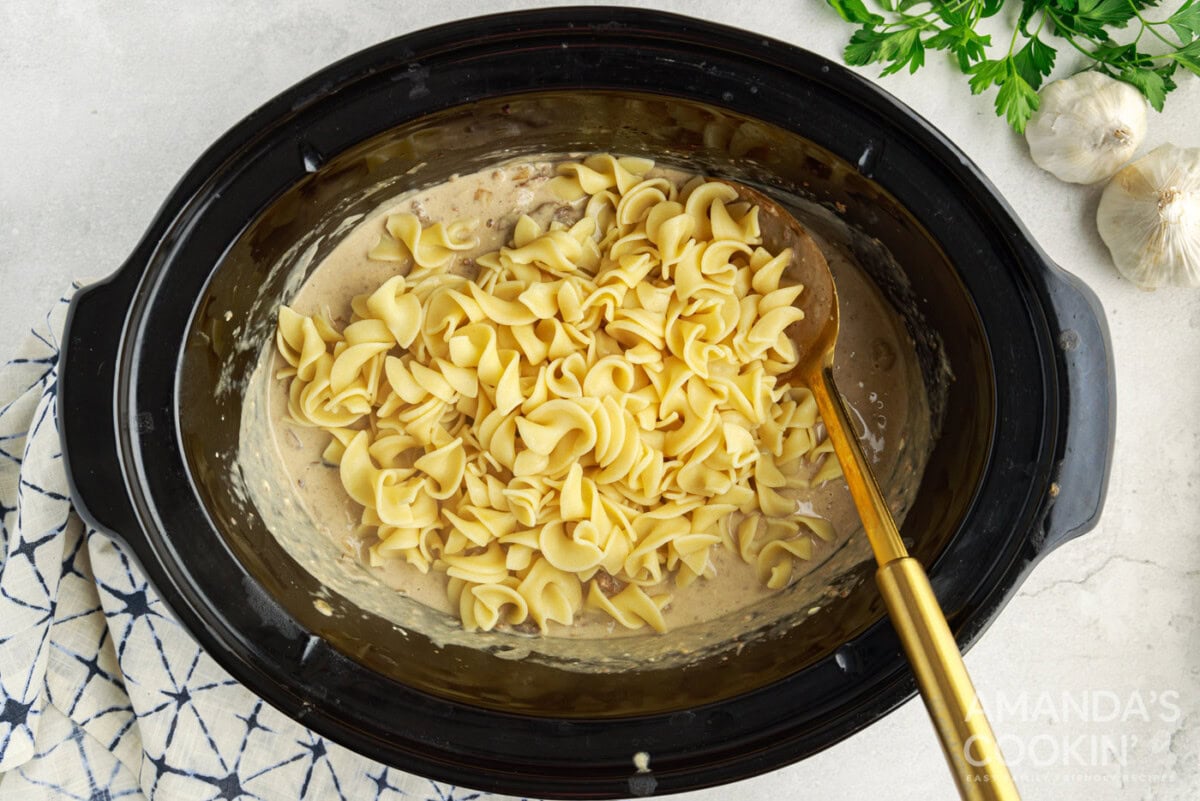 egg noodles mixed into beef stroganoff in the crockpot