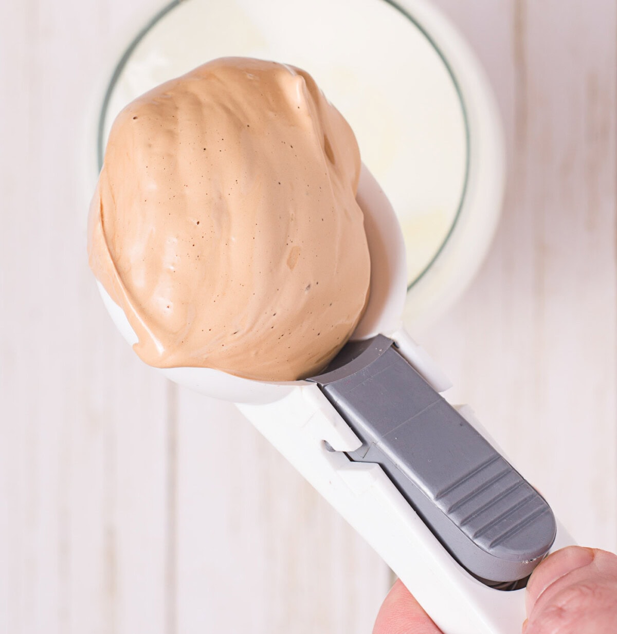 scooping dalgona coffee into milk