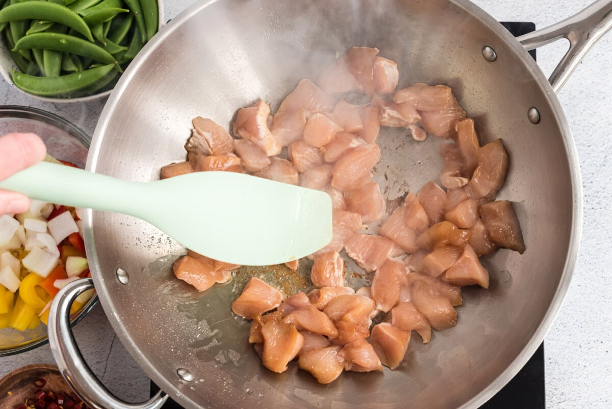 chicken in a wok pan frying