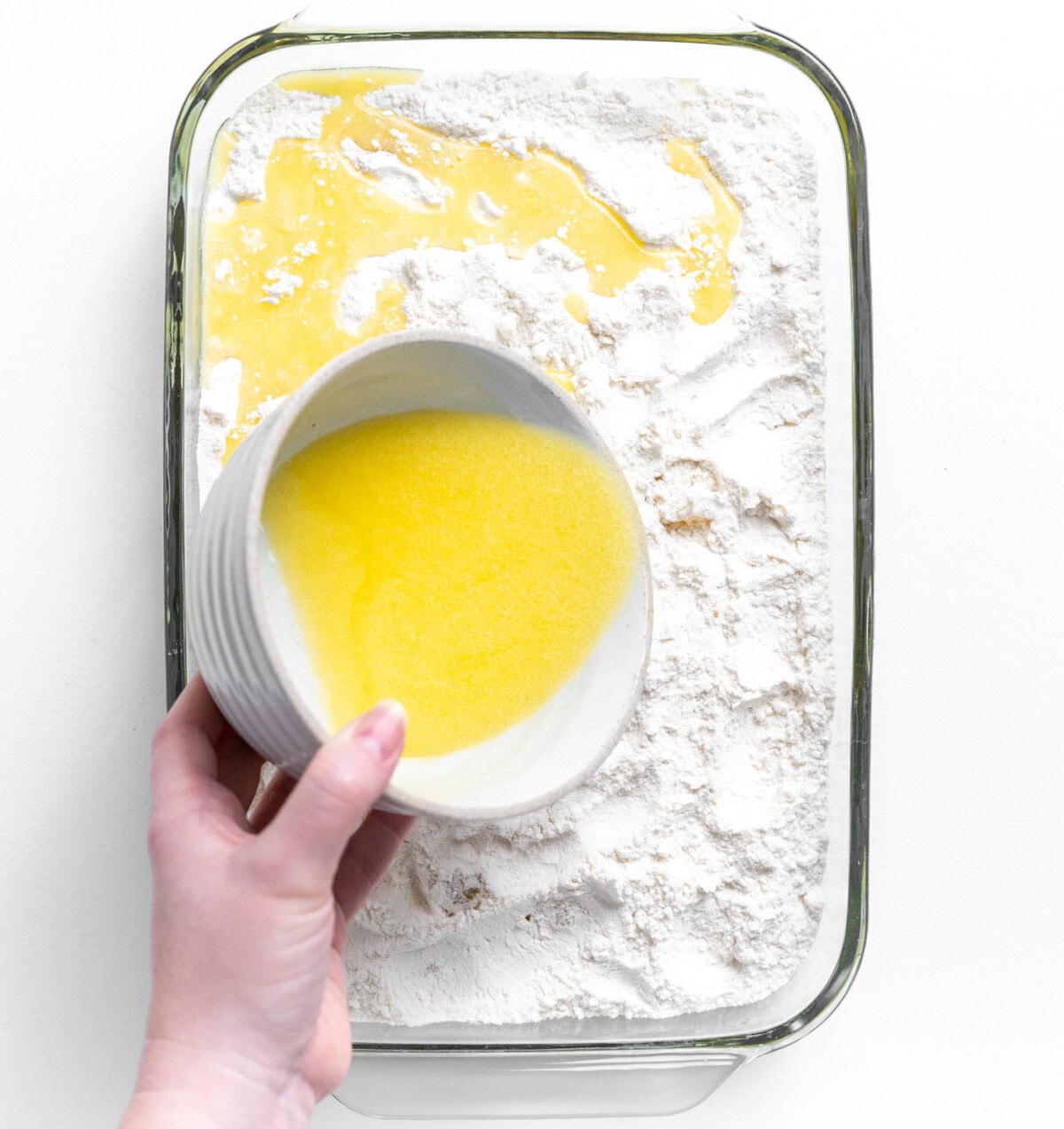 pouring melted butter over dump cake