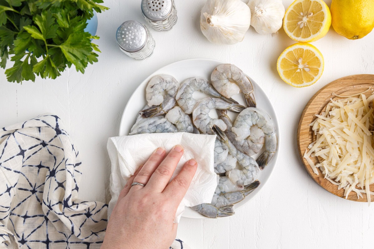 patting shrimp dry with a paper towel