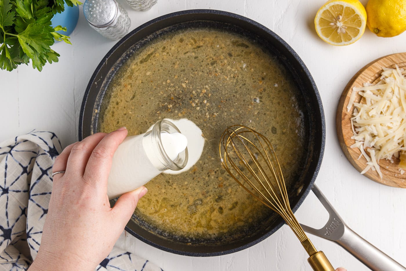 adding milk to a skillet of butter and lemon juice