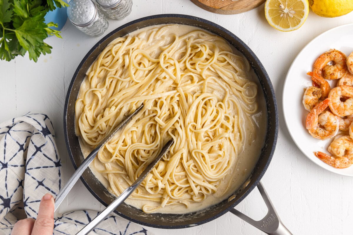 tossing noodles in lemon garlic sauce