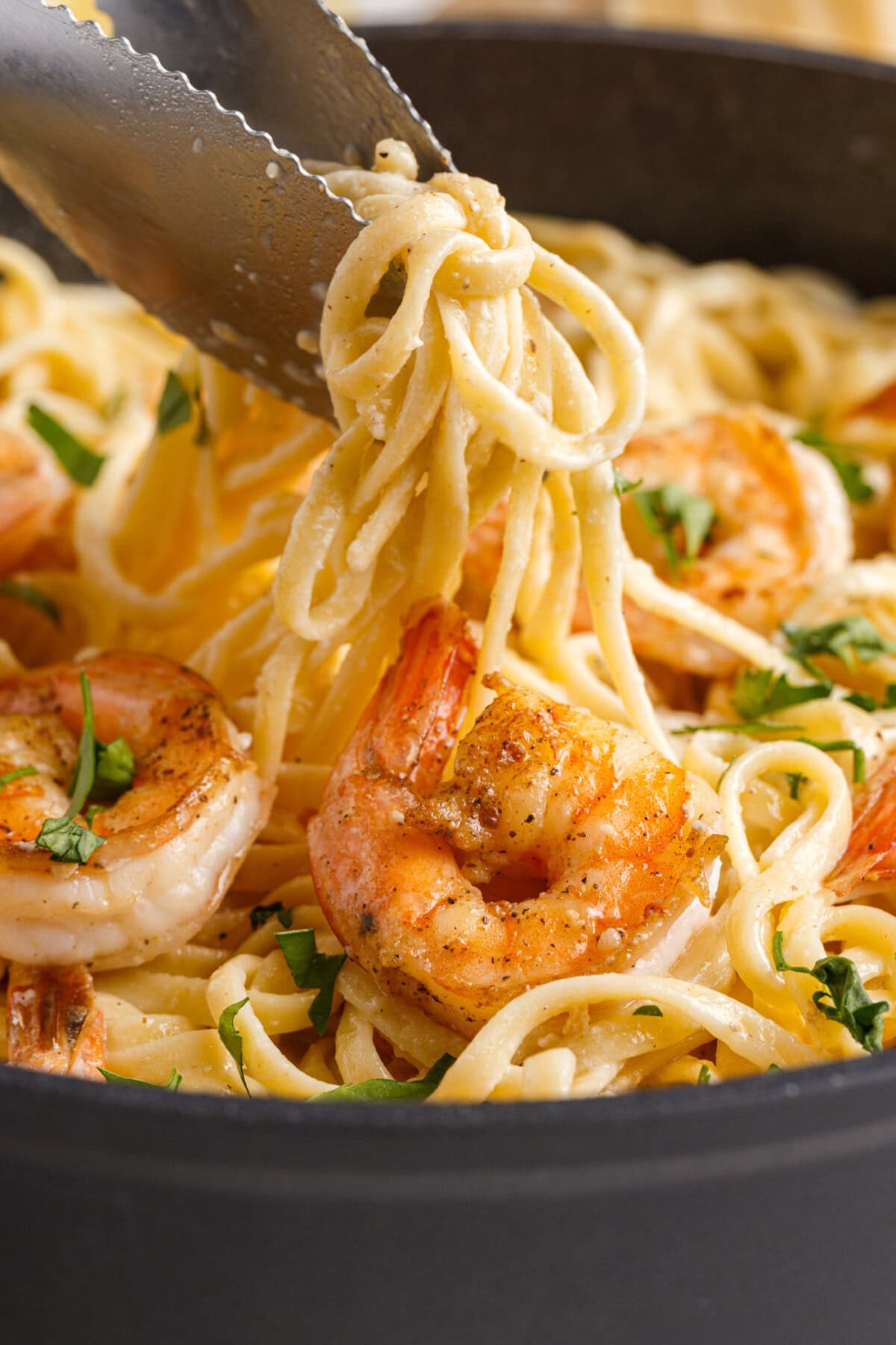 tongs lifting Shrimp Pasta
