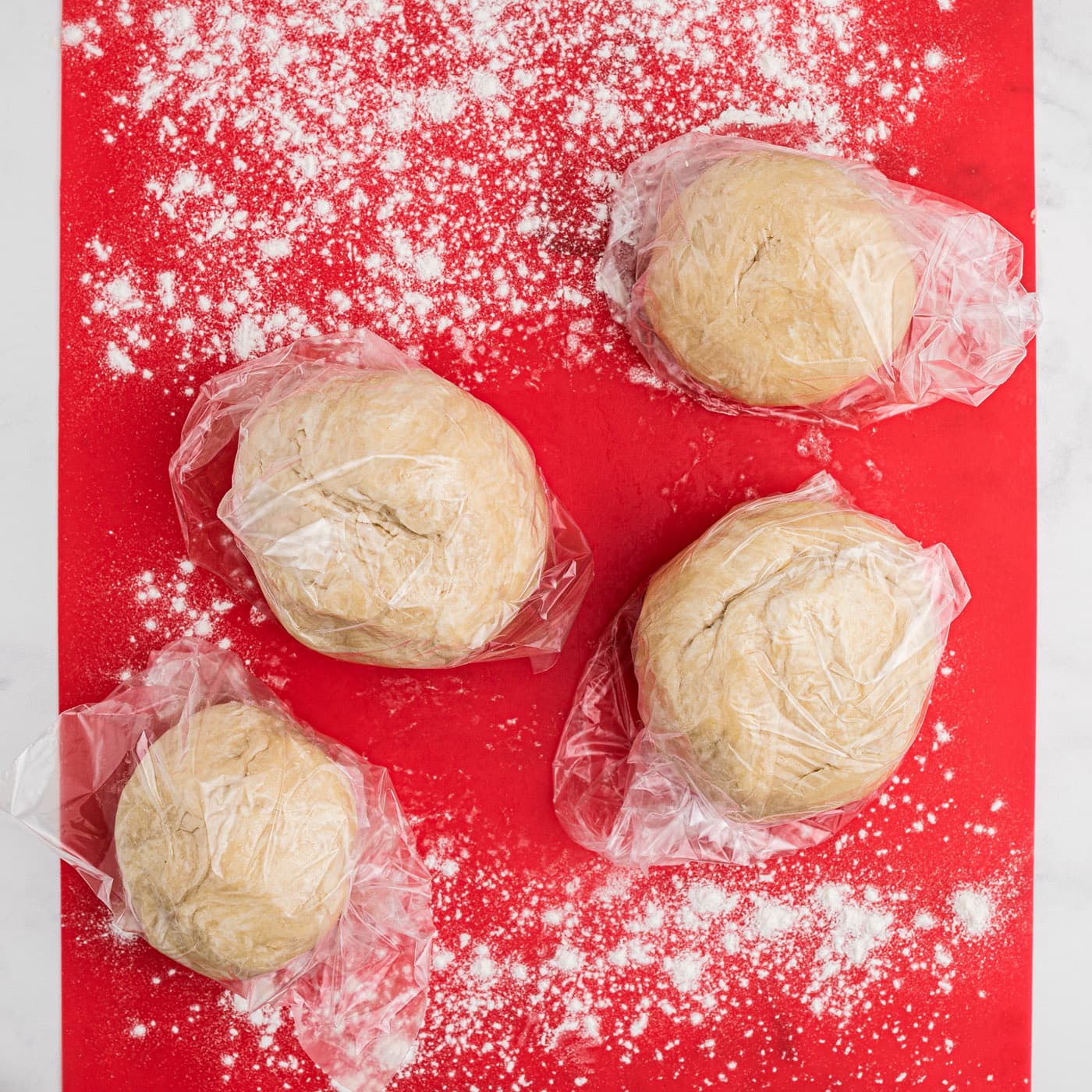 small pie dough balls on floured surface