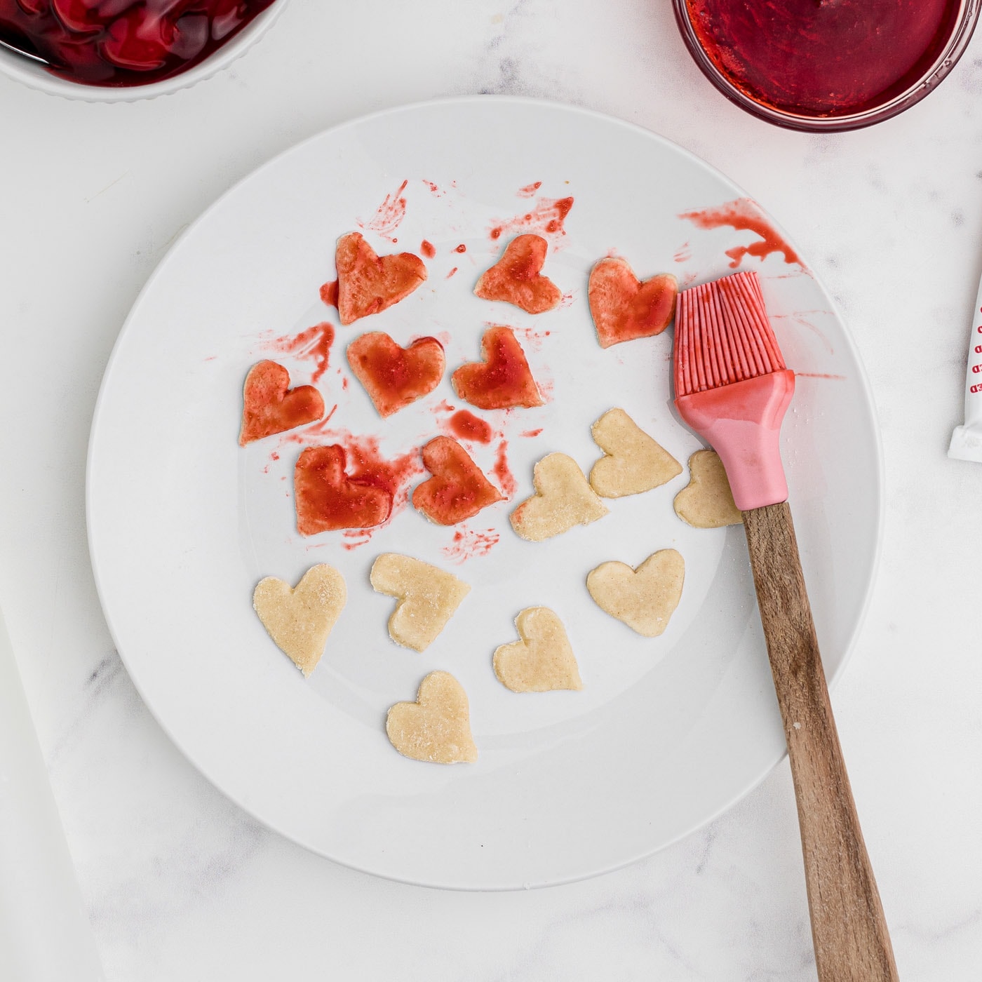 brushing heart pie dough with red food color
