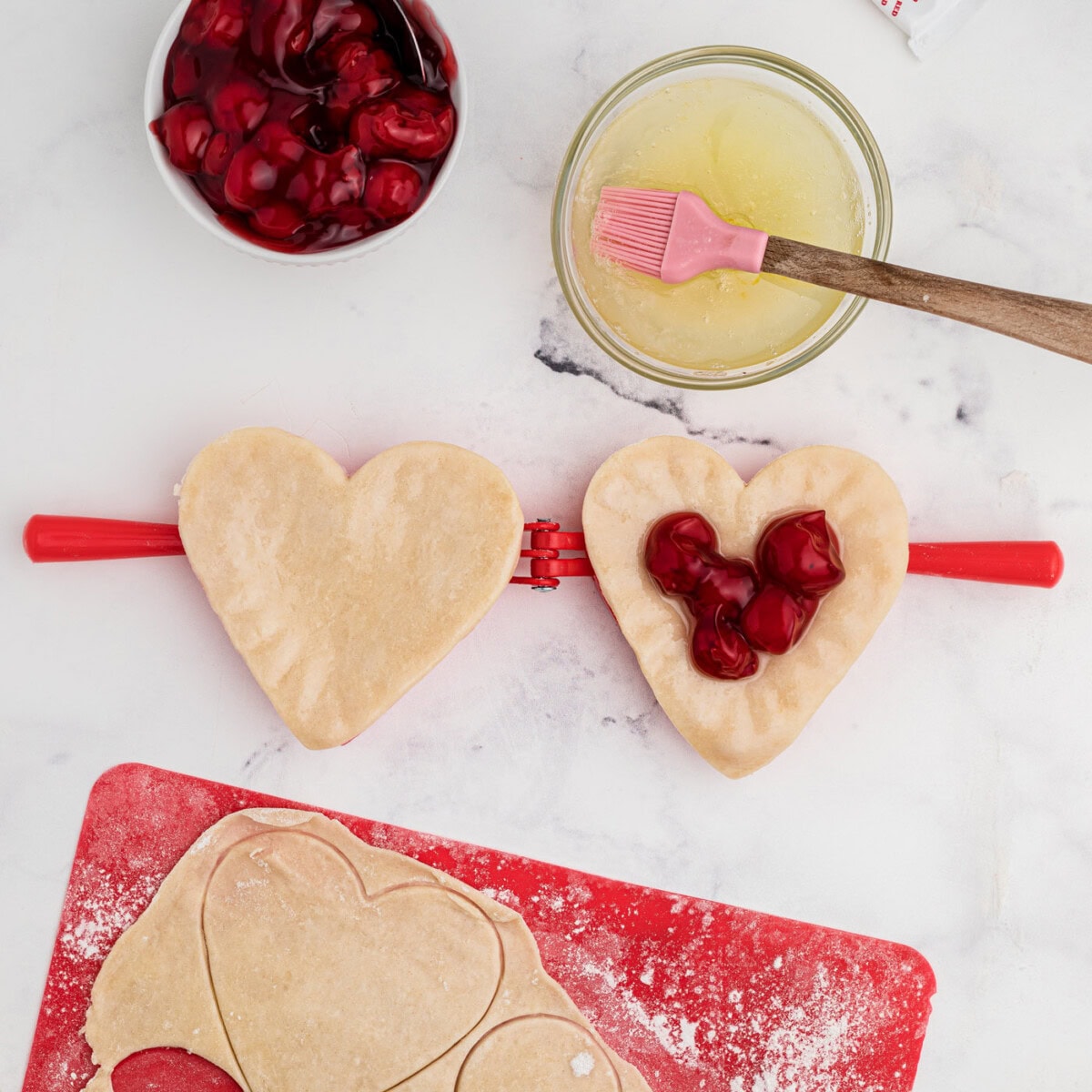 cherry pie filling inside heart shaped pie dough