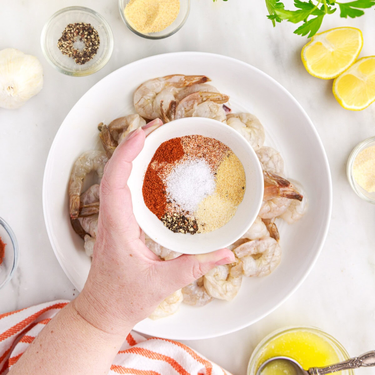 sprinkling seasonings over shrimp