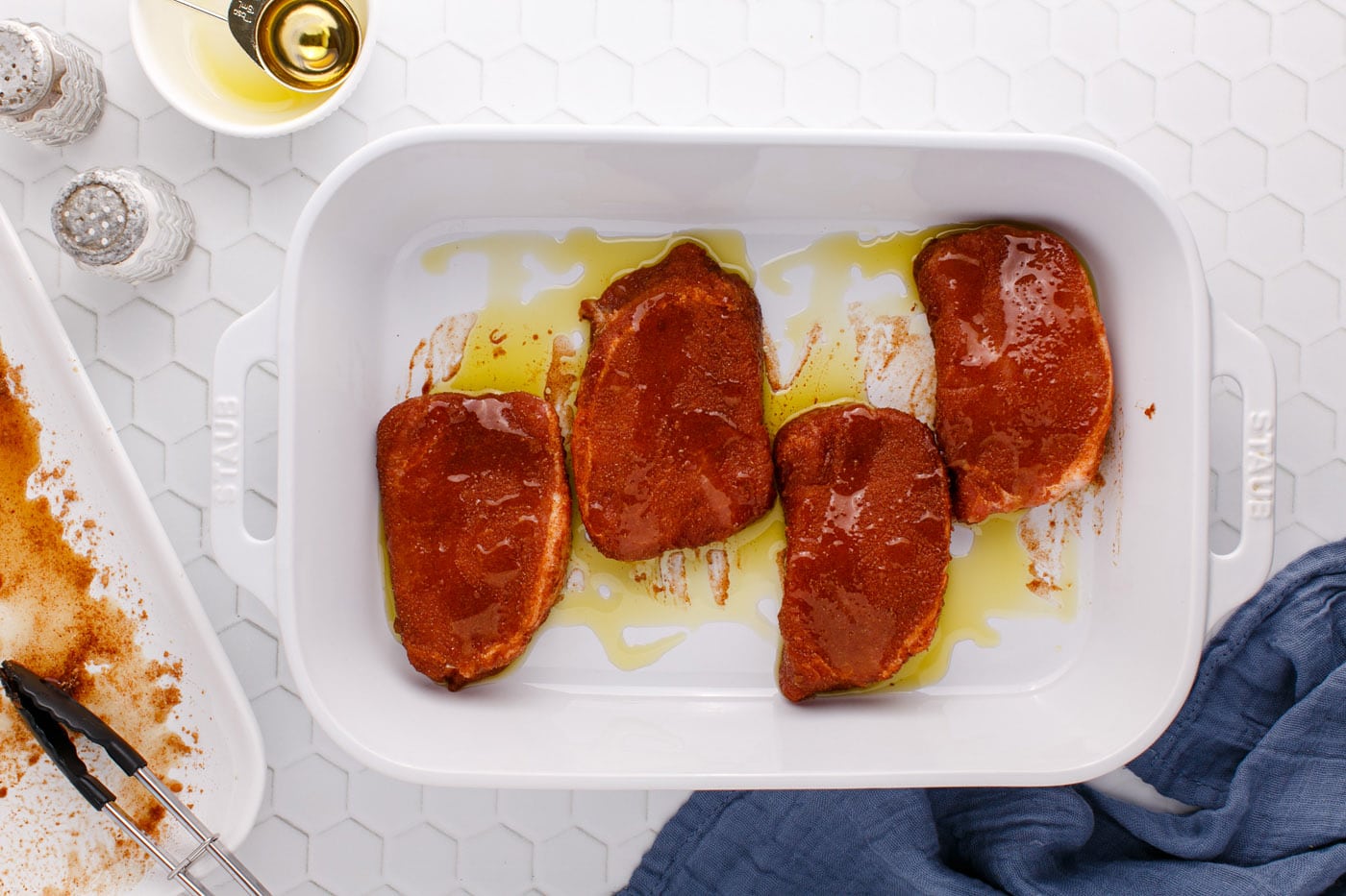 pork chops in a baking sheet with olive oil