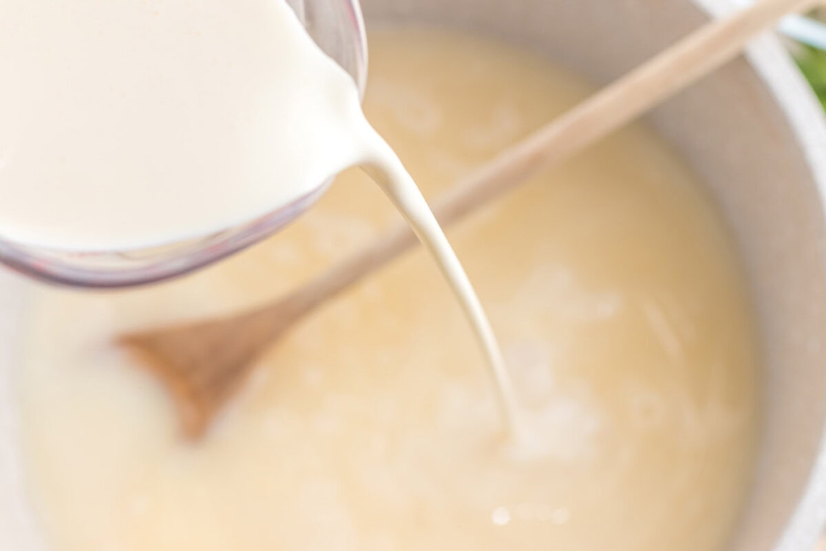 pouring heavy cream into pot