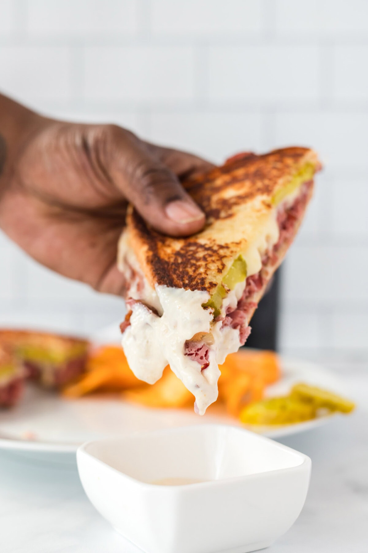 dipping Corned Beef Sandwich in sauce