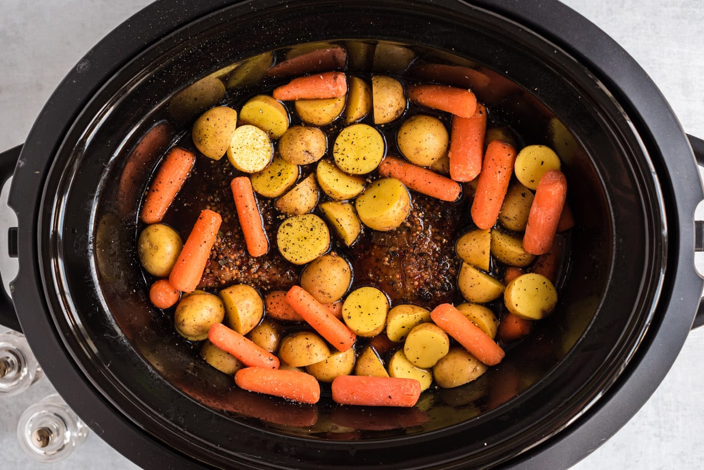 baby carrots and potatoes in a crockpot with corned beef