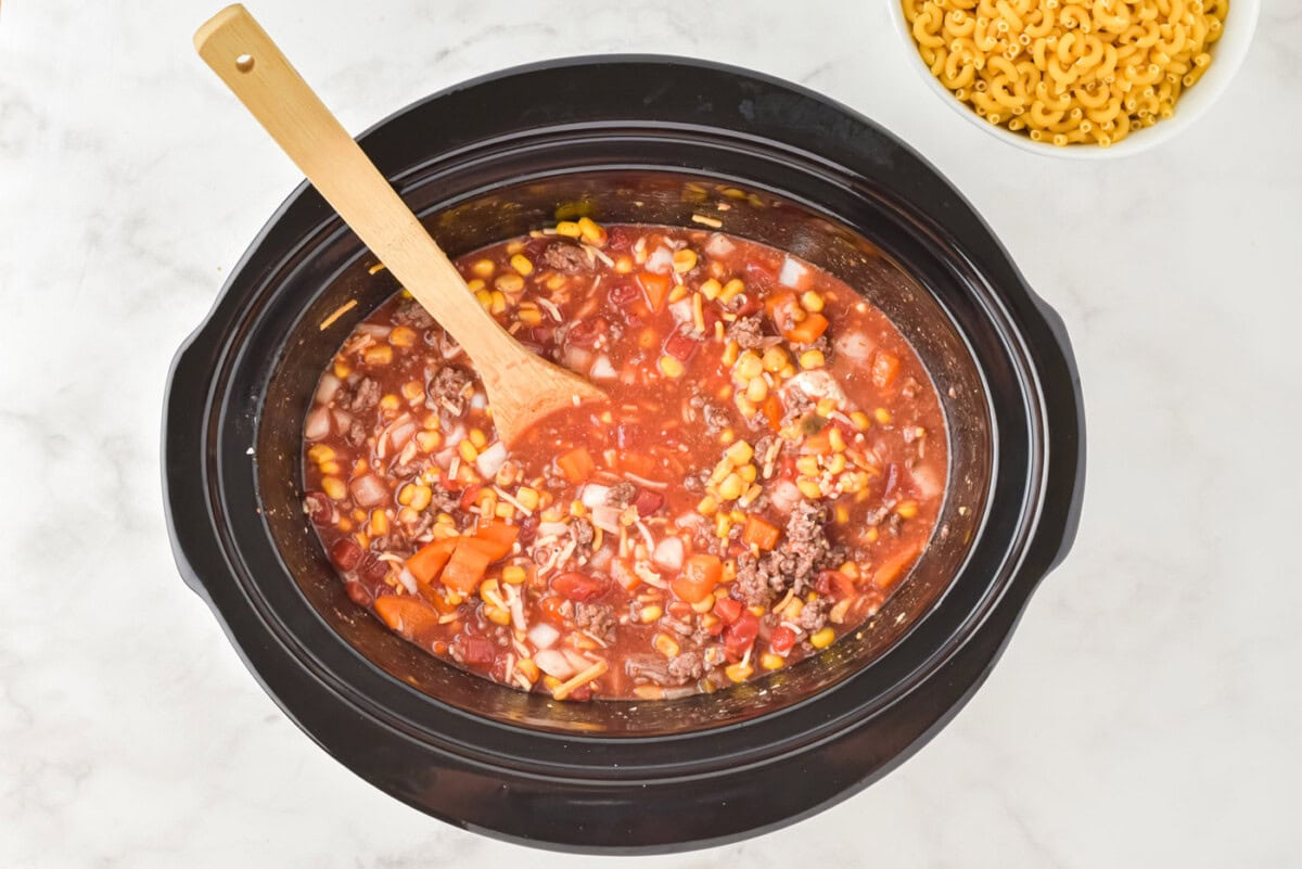 wooden spoon stirring ingredients in a crockpot