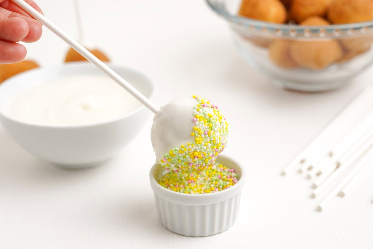 dipping cake pop into sprinkles