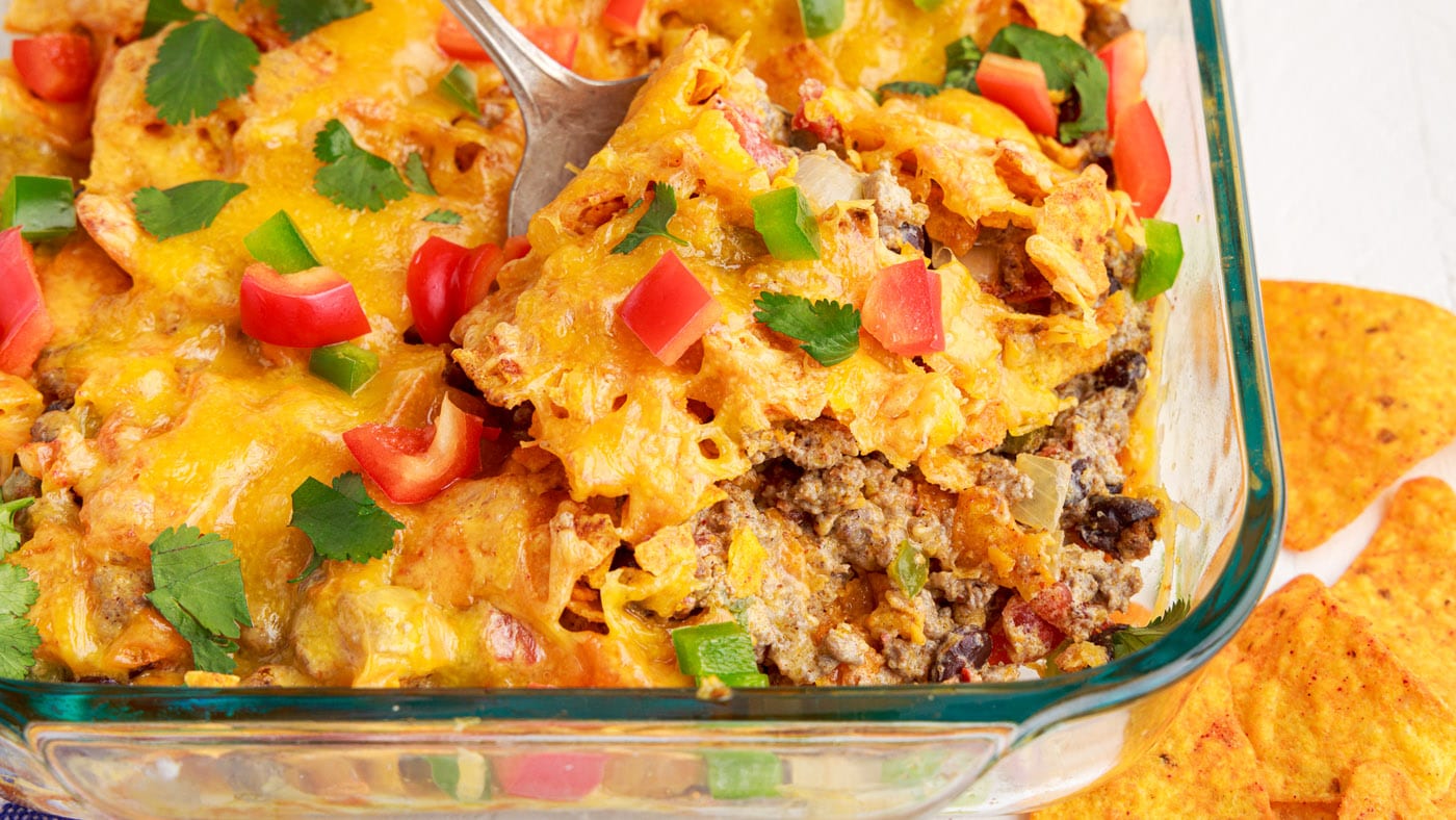 With layers of crunchy nacho cheese chips, ground beef, onion, bell peppers, beans, and loads of che