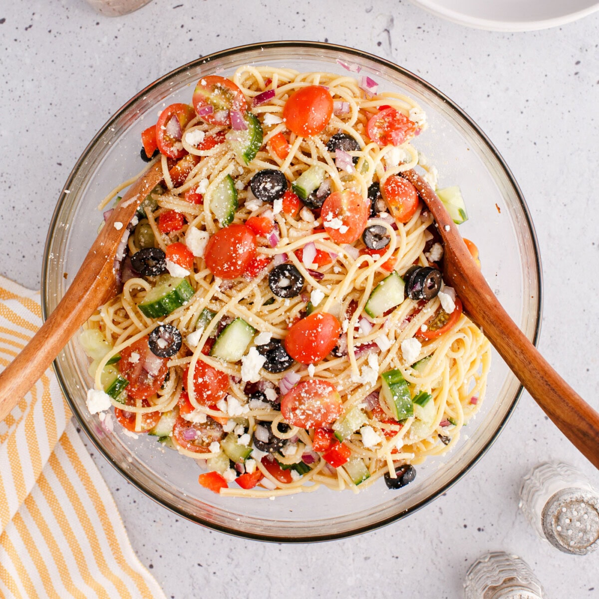 spaghetti salad in a bowl with wooden spoons