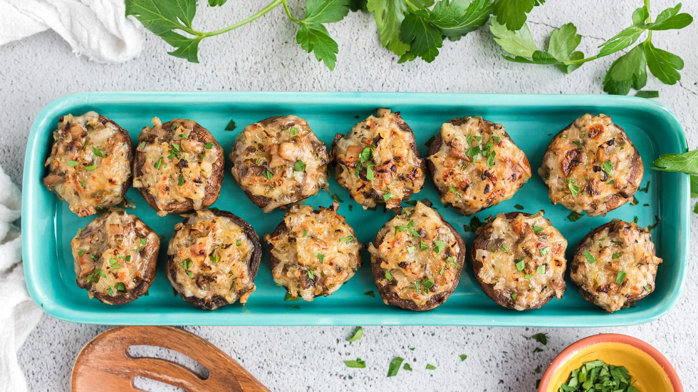 These savory stuffed mushrooms are packed with melty cheese, diced onions, minced parsley, and dried
