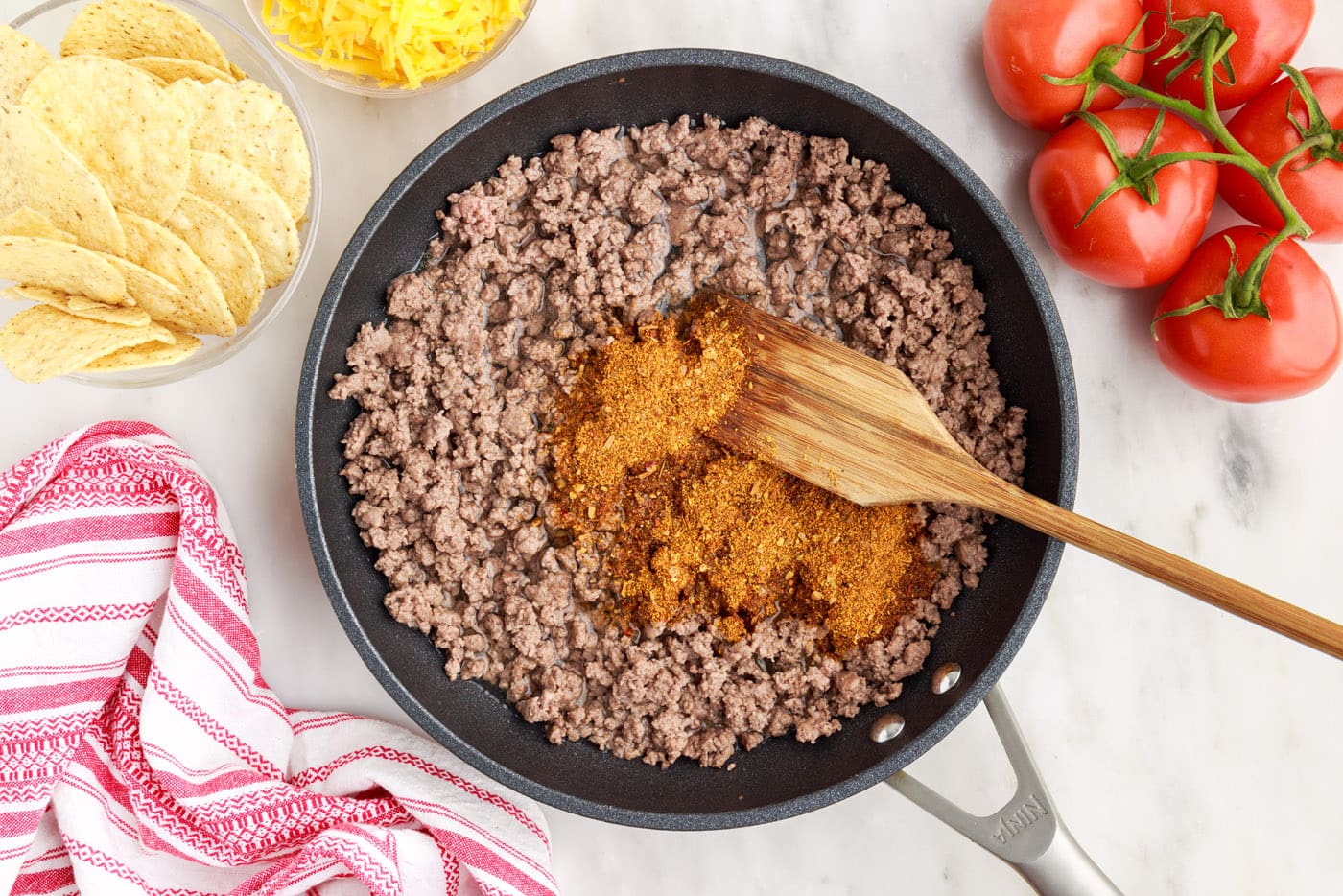 browning ground beef in skillet with taco seasoning