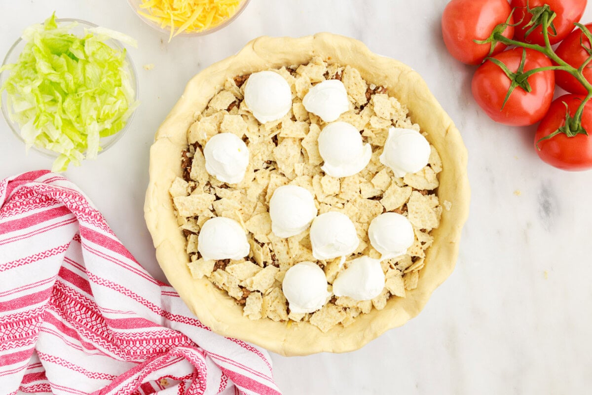 dollops of sour cream over chips and ground beef