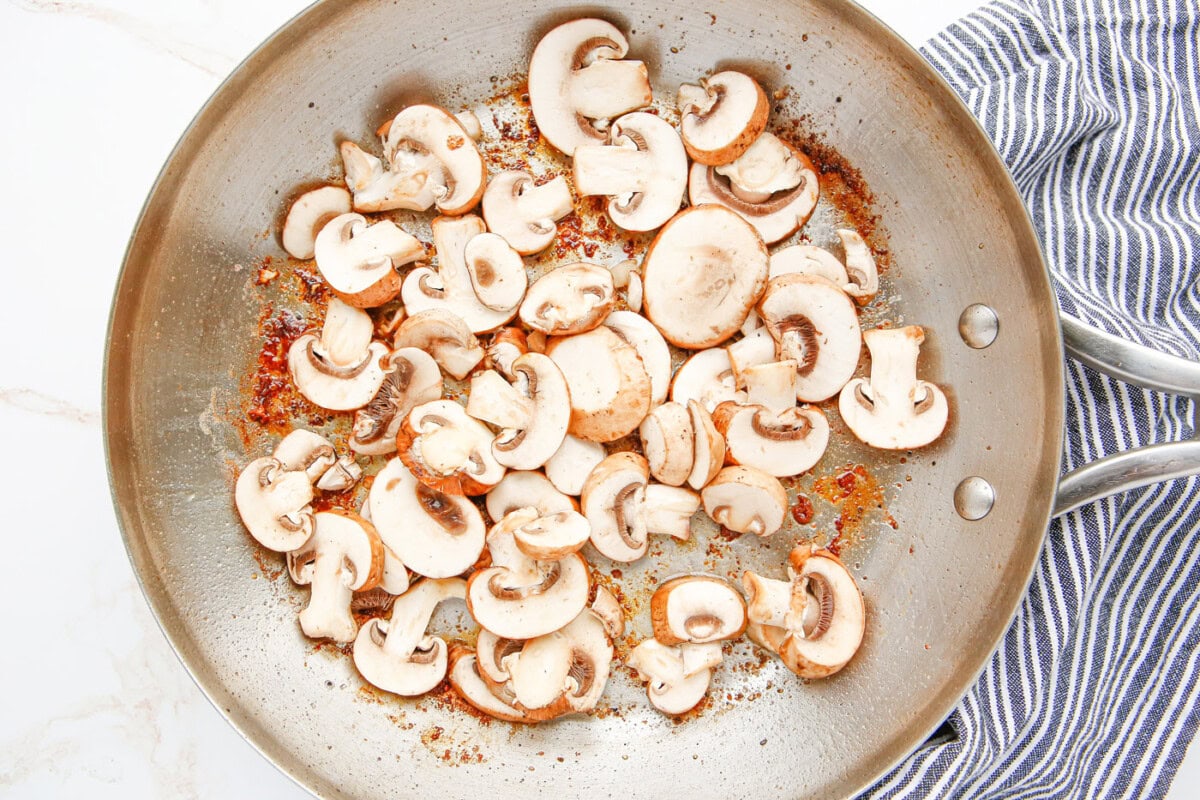 sliced mushrooms in a skillet with butter