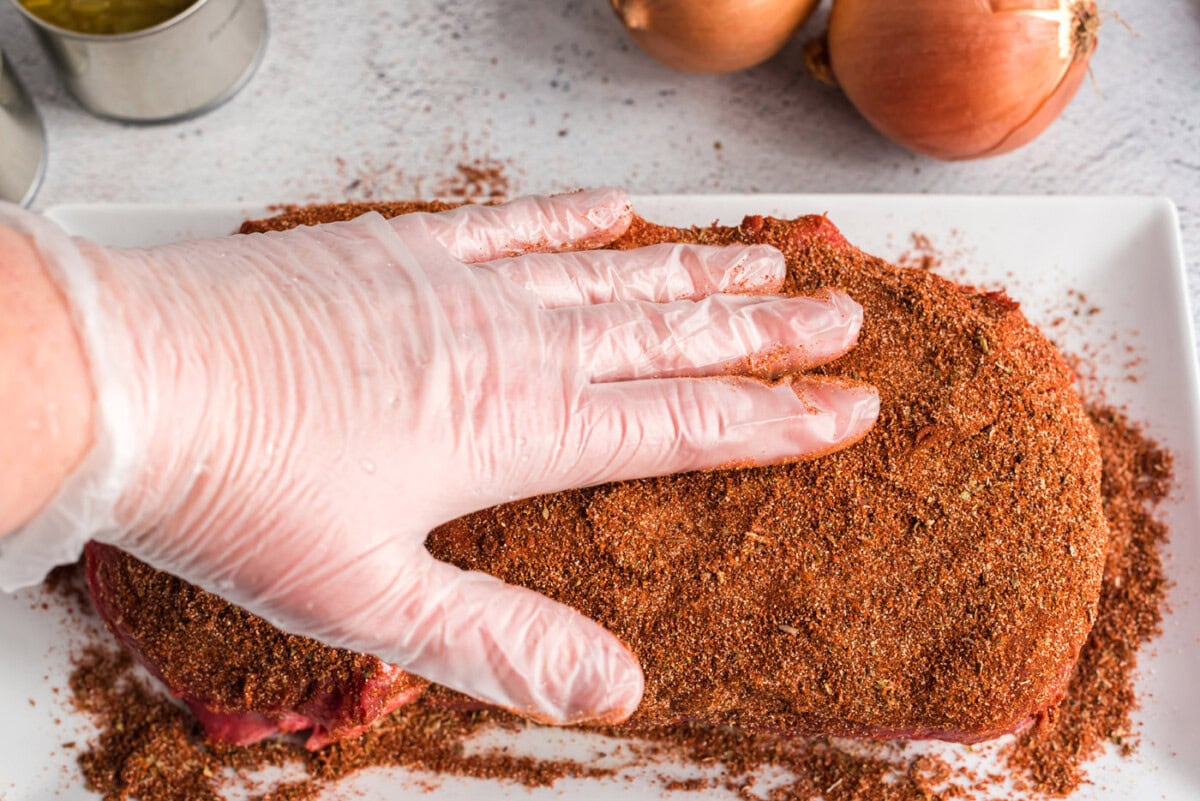 rubbing seasoning into chuck roast