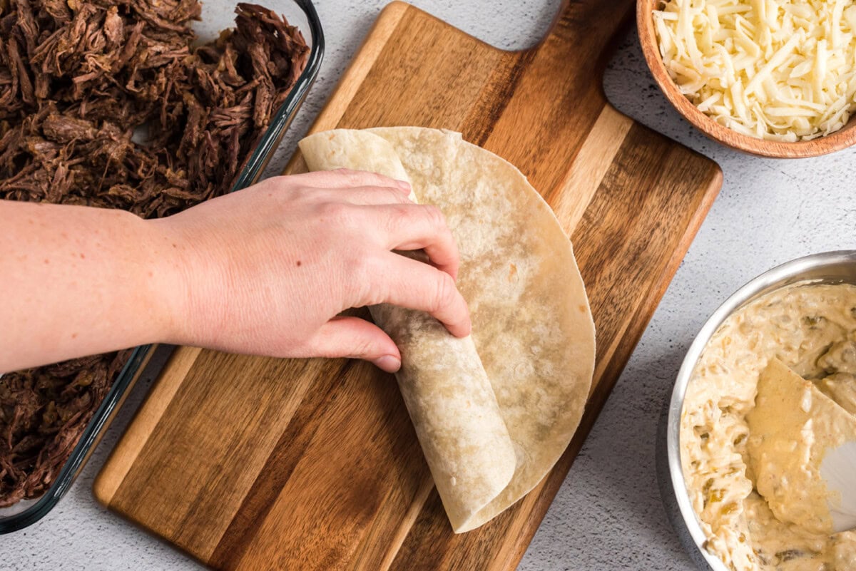 rolling up beef enchiladas