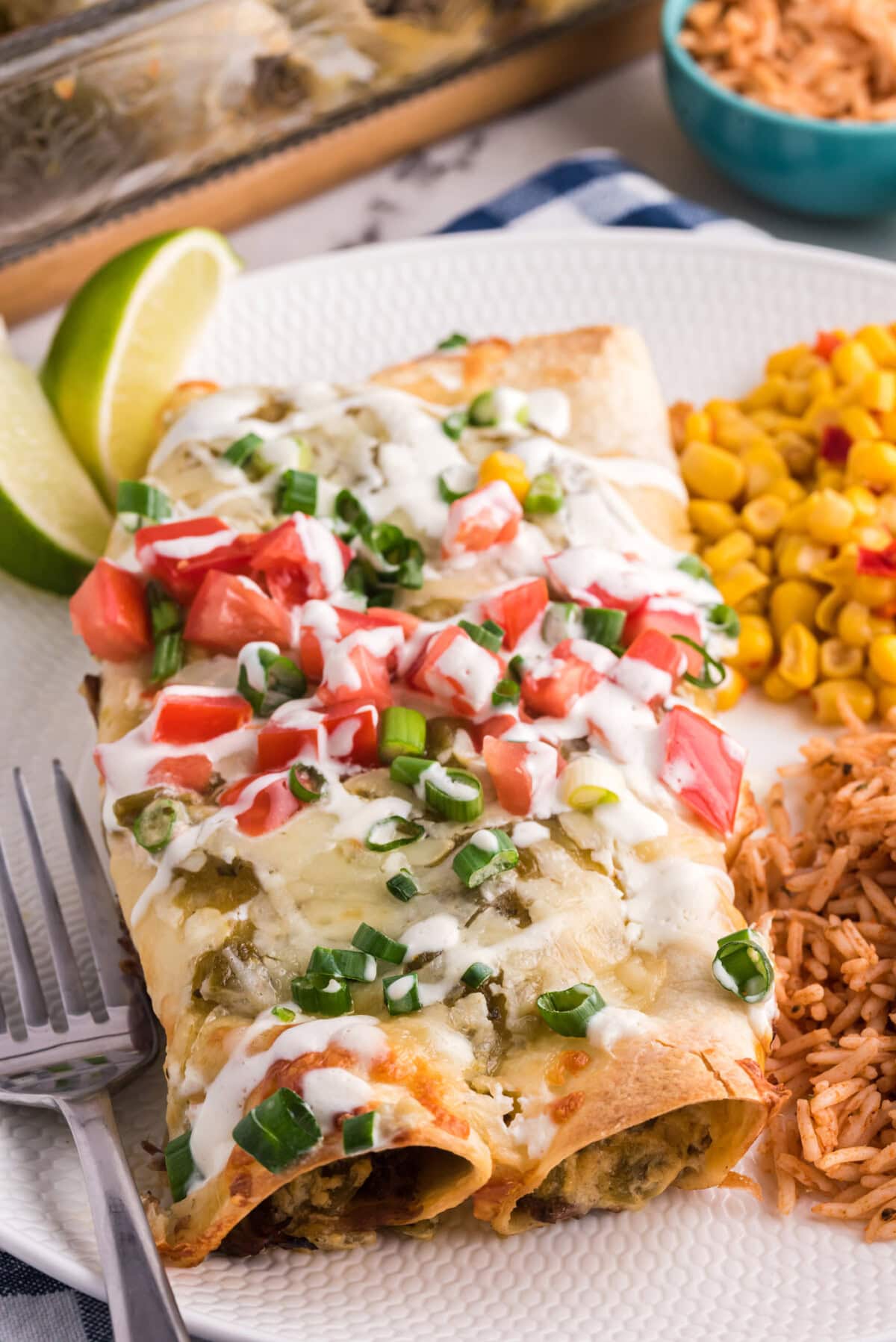 Close up photo of Beef Enchiladas on a plate with rice and corn