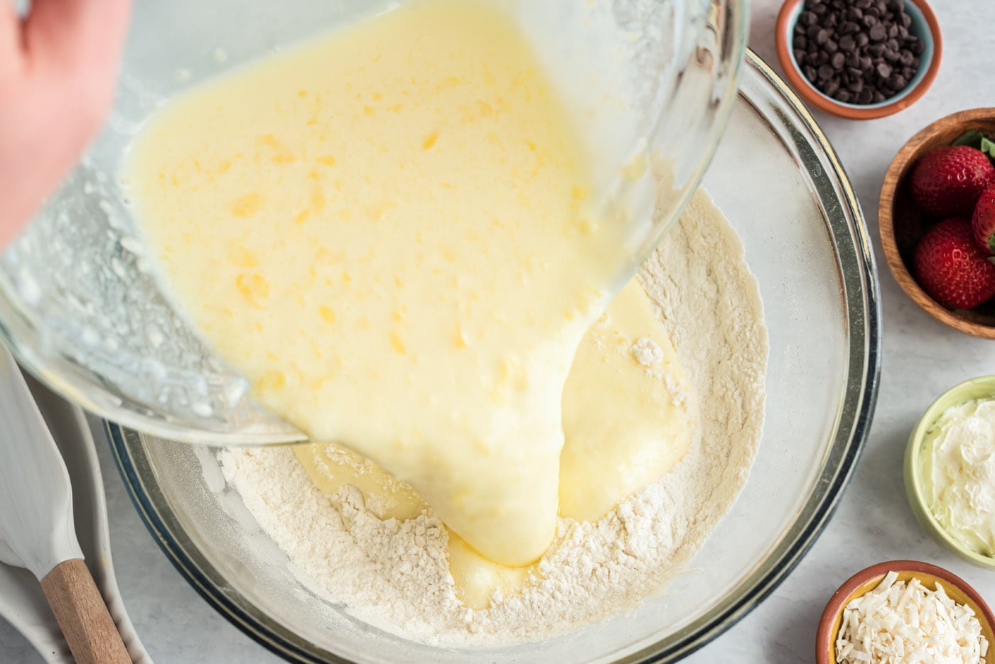 adding wet ingredients to dry pancake ingredients