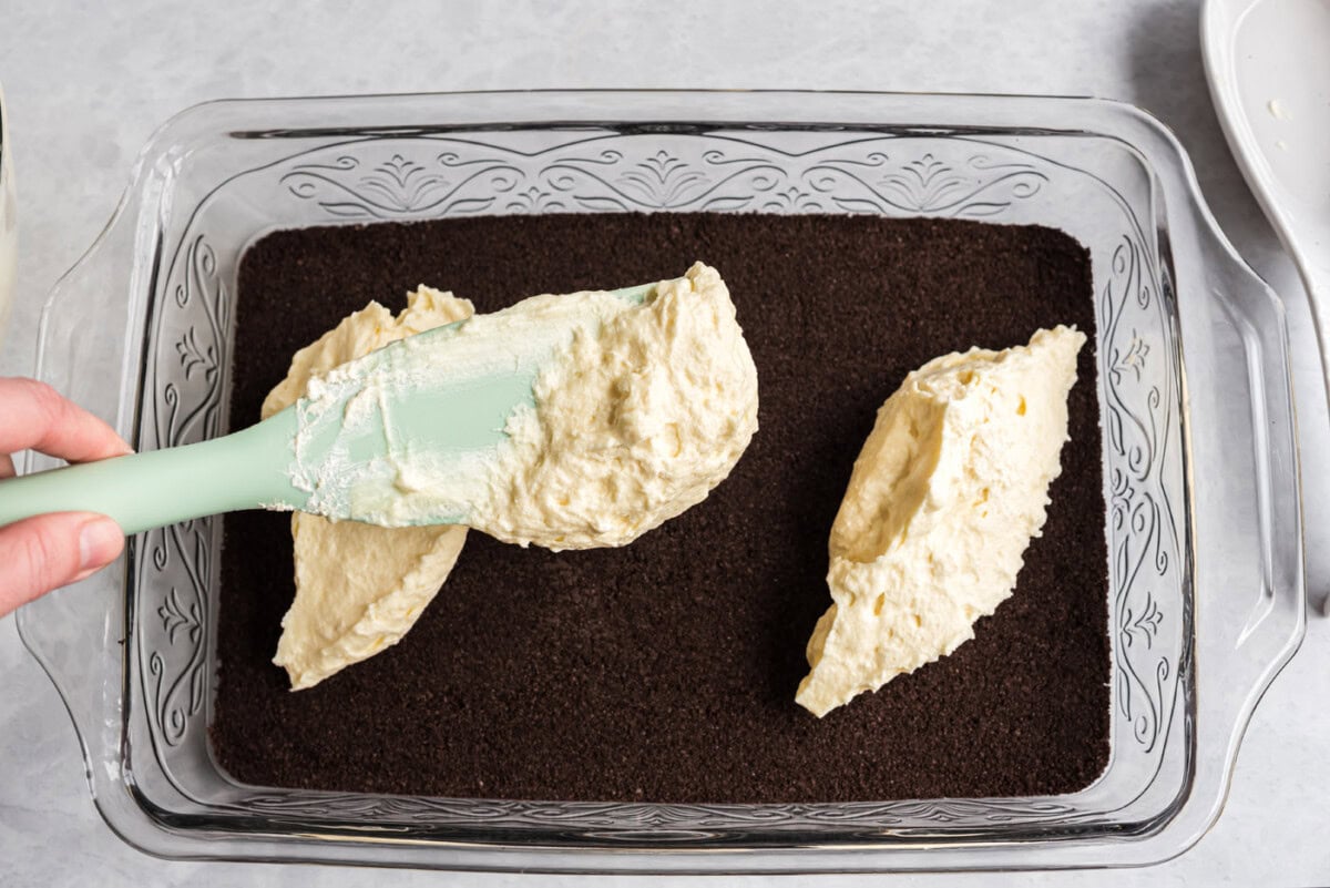 spreading cream cheese mixture on top of oreo crust