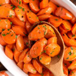 wooden spoon lifting Glazed Carrots